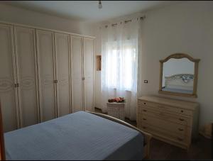 a bedroom with a bed and a mirror and a dresser at Villa Sofia in Capo Rizzuto