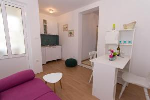 Apartments Kruno في ميديوغوريه: غرفة معيشة مع أريكة أرجوانية وطاولة