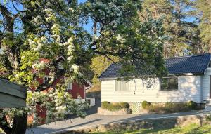 a white house with a tree in front of it at 2 Bedroom Lovely Home In Færvik in Færvik +10 photos