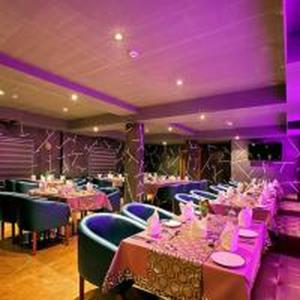 a restaurant with tables and chairs and purple lighting at Park Residency Kodungallur in Trichūr +28 photos