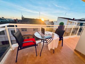 balcone con tavolo, sedie e computer portatile di Vibra Delta a Sant Jaume d'Enveja
