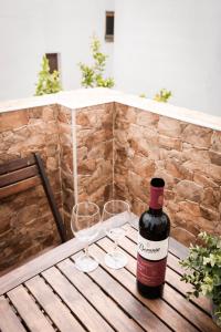 a bottle of wine sitting on a wooden table with two glasses at Casa Thula - Hello Vejer in Vejer de la Frontera