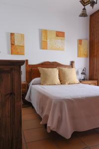 a bedroom with a bed with a wooden headboard at Casa Thula - Hello Vejer in Vejer de la Frontera