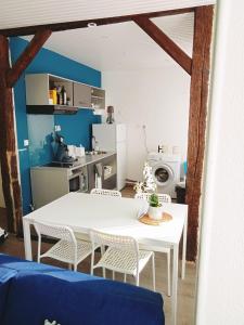 a dining room with a white table and chairs at Le petit refuge de Venose in La Châtre