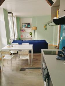 a living room with a table and a blue couch at Le petit refuge de Venose in La Châtre +2 photos