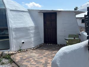 洛尔卡Pink Elephant的一间白色的小房子,设有门和庭院