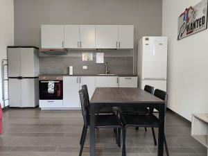 - une cuisine avec une table et des appareils électroménagers blancs dans l'établissement Liberty House Alps, à Châtillon