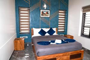 Un dormitorio con una cama con paredes azules. en ECOSTAY inn, en Sultan Bathery
