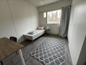 a small room with a bed and a window at Puomitie for 3 persons in Kajaani