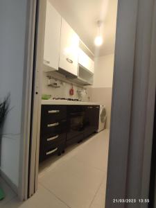 a kitchen with white cabinets and a microwave at Casa Messina in Messina