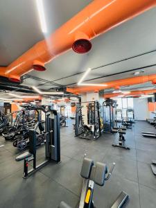 a gym with lots of tread machines and orange pipes at فندق الأمراء بلازا in Ma‘ān