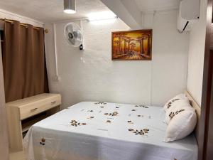 a bed in a room with a painting on the wall at Ashvina Lodge in Flic-en-Flac