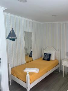 Cama en habitación con pared a rayas en Flipflops Apartment, en Nazaré 17 fotos más