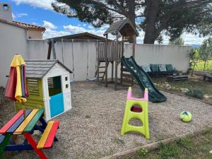 a playground with a slide and a play house at Villa au calme avec piscine in Saint-Jean-de-Fos