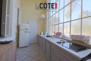 a kitchen with a white refrigerator and a window at Château Charles Roux in Sausset-les-Pins +16 photos