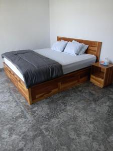 a bedroom with a bed with a wooden frame at Sumbul Harmony in Airsatang