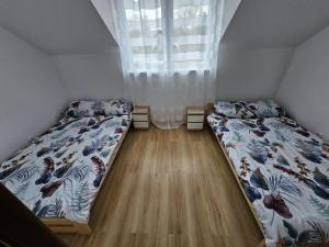 sypialnia z dwoma łóżkami i oknem w obiekcie Baltichouse Podczele- domki wakacyjne blisko morza !!! sauna, jacuzzi,grill plac zabaw w Kołobrzegu +26 zdjęć
