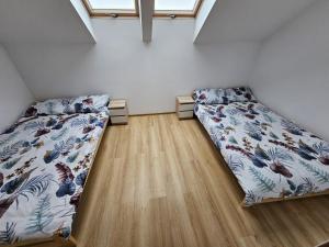 sypialnia z 2 łóżkami i drewnianą podłogą w obiekcie Baltichouse Podczele- domki wakacyjne blisko morza !!! sauna, jacuzzi,grill plac zabaw w Kołobrzegu