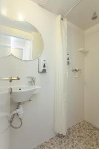 モスクワにあるレトロ モスクワ ホテル オン アルバートの白いバスルーム(シンク、シャワー付)