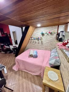 a bedroom with a pink bed and a brick wall at JS turismo imobiliário in Angra dos Reis
