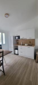cocina con armarios blancos y suelo de madera en Bastide Collection, en Cherbourg-en-Cotentin