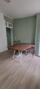 una gran mesa de madera en una habitación vacía en Bastide Collection, en Cherbourg-en-Cotentin
