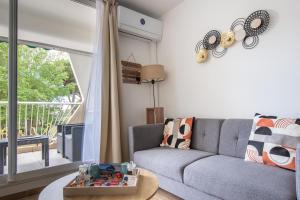 a living room with a couch and a table at Le sable et pinède in La Grande-Motte +39 photos
