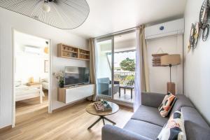 a living room with a couch and a tv at Le sable et pinède in La Grande-Motte