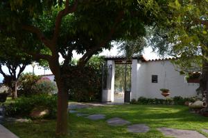 una casa bianca con un albero in cortile di Azienda Agrituristica Villa Arianna a Imperia