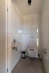 a white bathroom with a toilet and a sink at Enkhuizer Strand Chalet Suydersee Huys Nr 462 in Enkhuizen