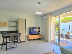 a living room with a television and a table and chairs at San Pietro Holiday Apartment - 288 in Durrës