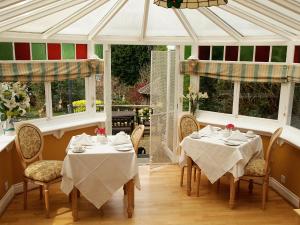 a dining room with two tables and two windows at Tower House 1066 in Hastings