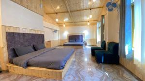 a bedroom with a bed and a couch and a chair at Purple House in Kasol +12 photos