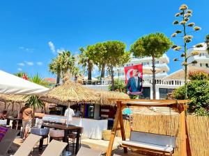 un patio con tavoli e sedie e un edificio di cunda panorama otel a Ayvalık