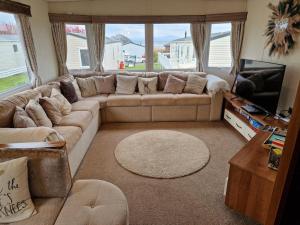 a living room with a couch and a television at Peaceful Seaside Getaway in Mainsriddle