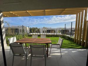 un tavolo e sedie di legno su un patio di Spacious Beach House in Malaga-Cala de Mijas, amazing see view, 3 bedroom, garden & Common Pool a Málaga