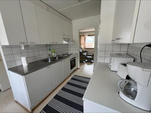 a white kitchen with a sink and a toilet at Ensitaival for 2 persons in Kajaani