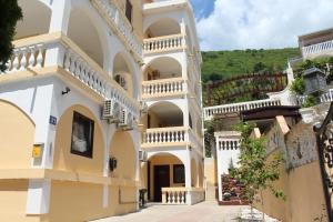 a building with arches and balconies on a street at Apartmani Lime in Petrovac na Moru