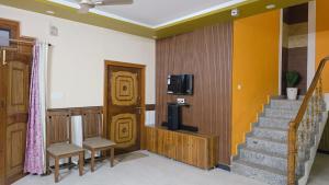 Zimmer mit einer Treppe, einem TV und einer Treppe in der Unterkunft VilleFortune 3BHK Cottage In Nainital in Bhīm Tāl