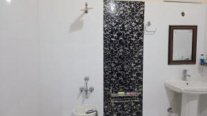 ein Badezimmer mit Waschbecken, Toilette und Spiegel in der Unterkunft VilleFortune 3BHK Cottage In Nainital in Bhīm Tāl + 79 Fotos