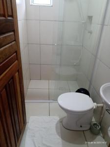 a white bathroom with a toilet and a shower at Kitnet da Adriana in Paraty +41 photos