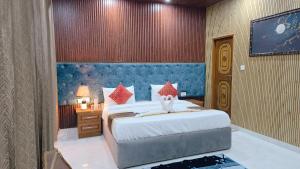 ein Schlafzimmer mit einem großen Bett mit blauem Kopfteil in der Unterkunft VilleFortune 3BHK Cottage In Nainital in Bhīm Tāl