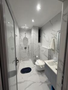 a white bathroom with a toilet and a sink at Eleana's Apartament in Sarandë +62 photos