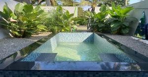 a pool in the middle of a yard with plants at Cherry Blossoms Chalet in Kozhikode