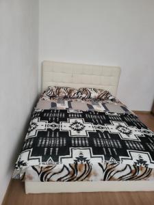 a bed with a black and white comforter at APARTMAJI Lea in Semedela
