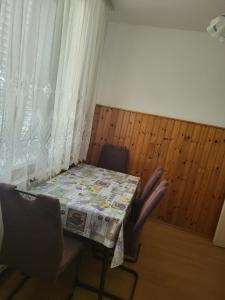 a table and chairs in a room with a window at APARTMAJI Lea in Semedela