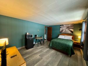 a room with a bed and a table and a microwave at West Pines Motel in Grand Rapids