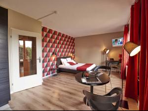 Sala de estar con cama y mesa en L'aparthoteL LhL, en Dijon