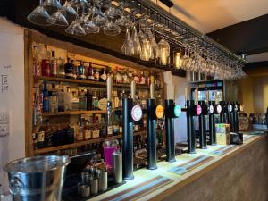 a bar with a bunch of bottles of alcohol at The Vale Hotel in Cricklade +11 photos