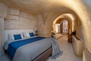 Un dormitorio con una cama grande en una habitación de piedra. en La grotta di Lulù, en Matera